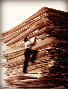 A Business Men Climbing a Pile of Papers